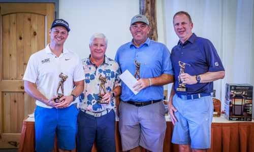 The 2023 winners of the IRMCA Scholarship Golf Outing smiling at the front of the awards presentation room.