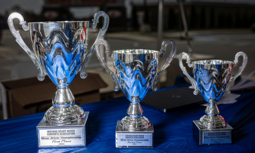 The top three trophies of the IRMCA Mixer Driver Competition displayed on the IRMCA blue tablecloth. The top three trophies of the IRMCA Mixer Driver Competition displayed on the IRMCA blue tablecloth.