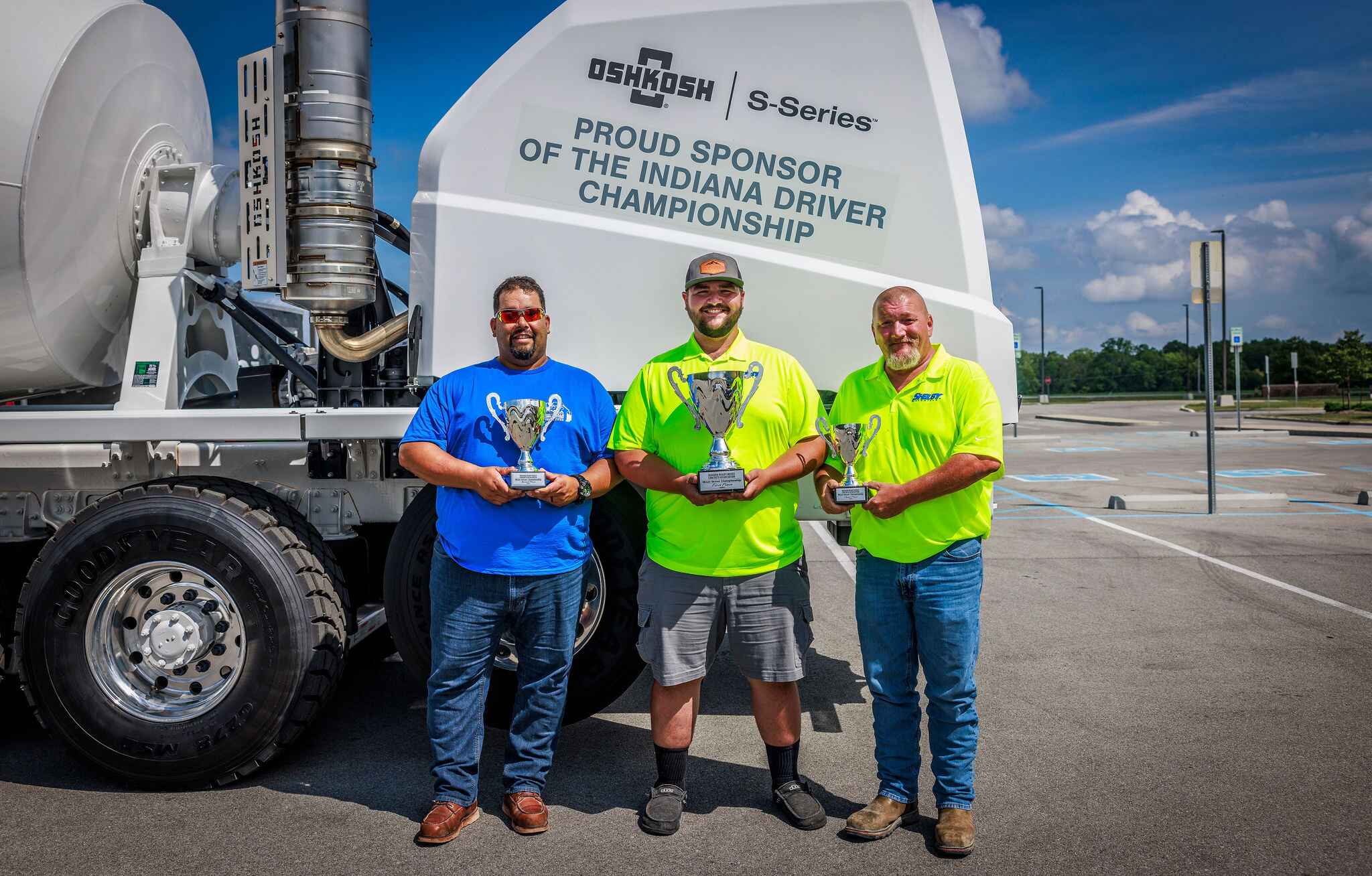 The 2024 Winners of the IRMCA Mixer Driver Championship pose in front of the Oshkosh S-Series concrete truck.